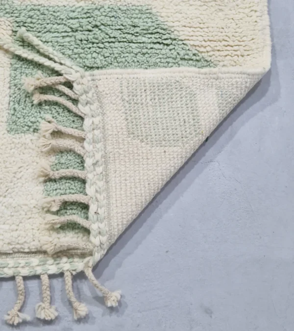 Detailed View of Handmade Moroccan rug with a modern abstract interlocking geometric design in neon green and off-white