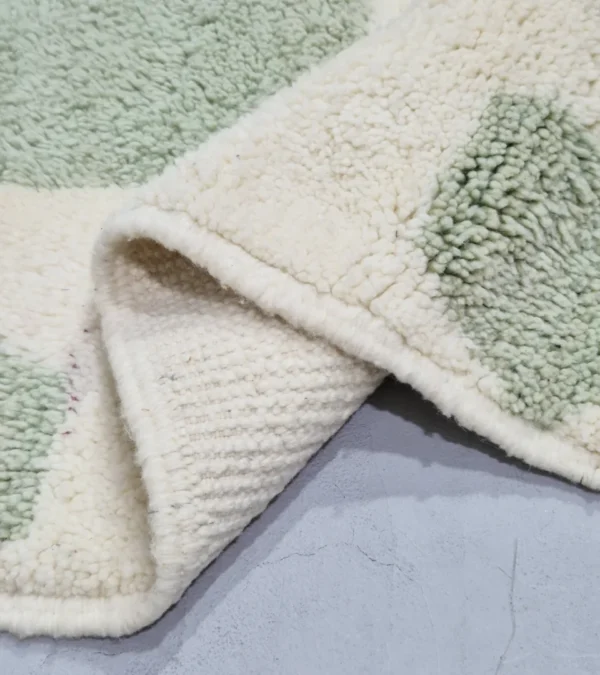 Detailed View of Handmade Moroccan rug with a modern abstract interlocking geometric design in neon green and off-white