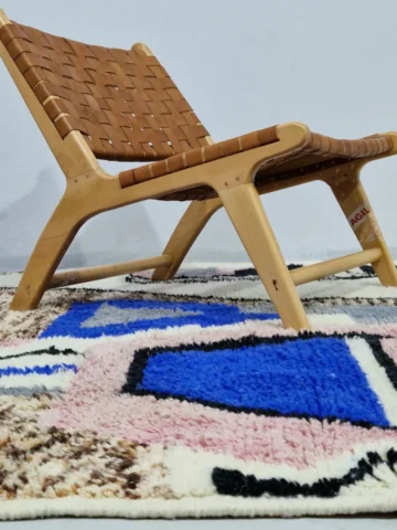 Handmade Moroccan wool rug with an abstract sketch design in pink, blue, brown, black, and off-white in room