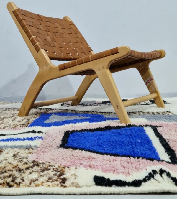 Handmade Moroccan wool rug with an abstract sketch design in pink, blue, brown, black, and off-white in room