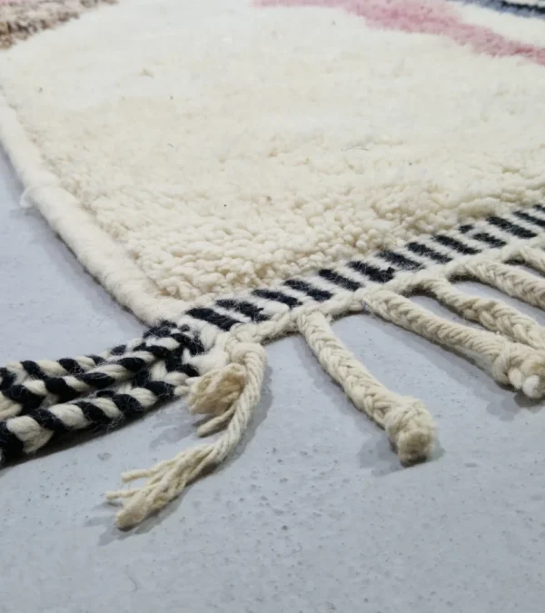 Detailed View of Handmade Moroccan wool rug with an abstract sketch design in pink, blue, brown, black, and off-white