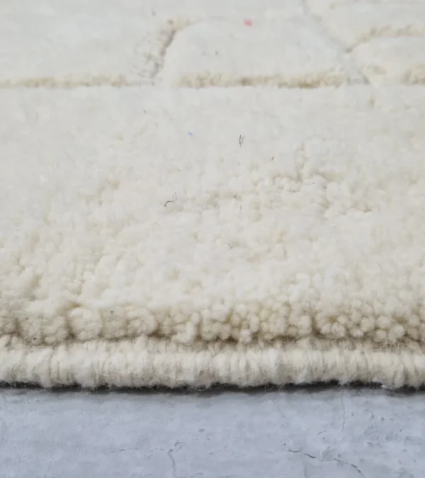 Zoomed In View of Handmade Moroccan wool rug in cream with raised abstract rectangles