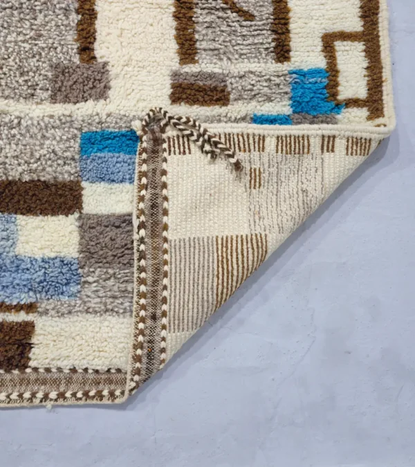 Detailed View of Orin handmade Azilal wool rug with an abstract linear design in gray, brown, ivory, and light blue