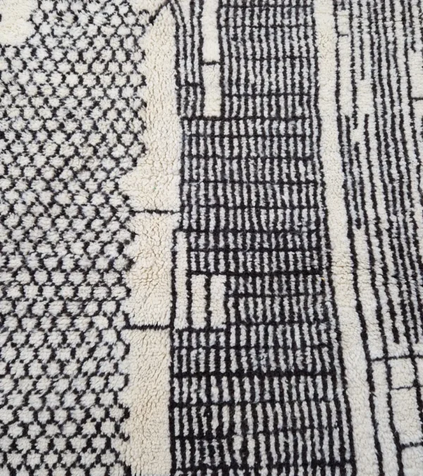 Detailed View of Riad handmade Moroccan wool rug with an intricate black and ivory textured design