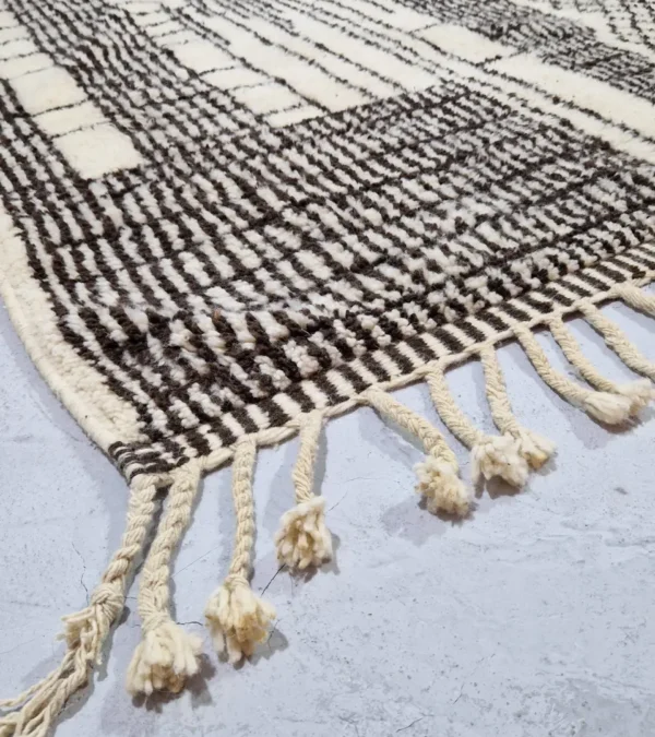 Detailed View of Riad handmade Moroccan wool rug with an intricate black and ivory textured design
