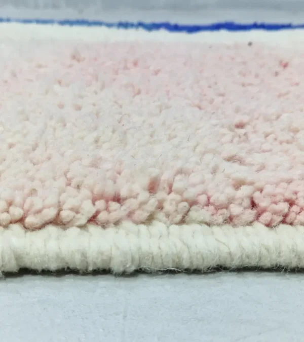 Zoomed In View of Rima handmade Beni Ourain wool rug with a contemporary abstract design in multicolor hues including blush pink, off-white, and royal blue to indigo