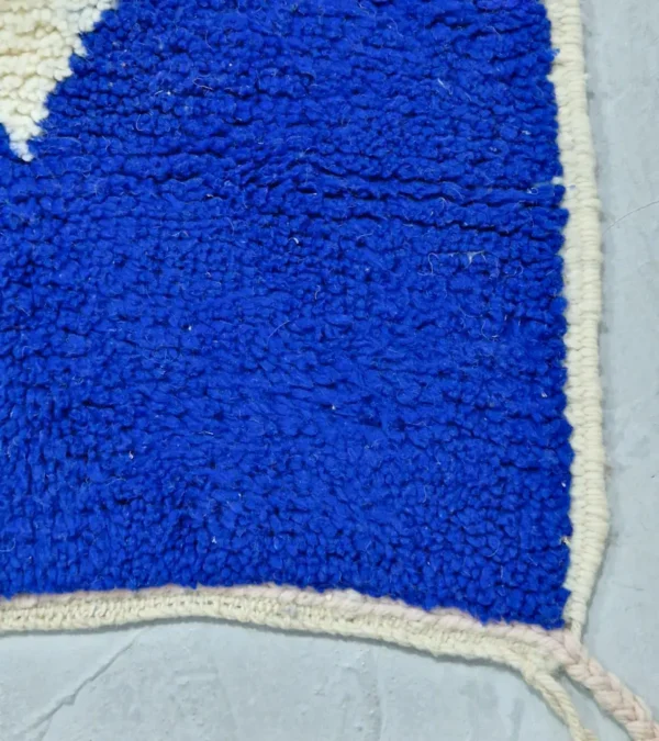 Detailed View of Rima handmade Beni Ourain wool rug with a contemporary abstract design in multicolor hues including blush pink, off-white, and royal blue to indigo
