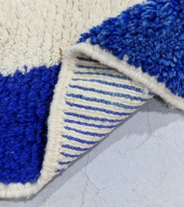 Detailed View of Rima handmade Beni Ourain wool rug with a contemporary abstract design in multicolor hues including blush pink, off-white, and royal blue to indigo