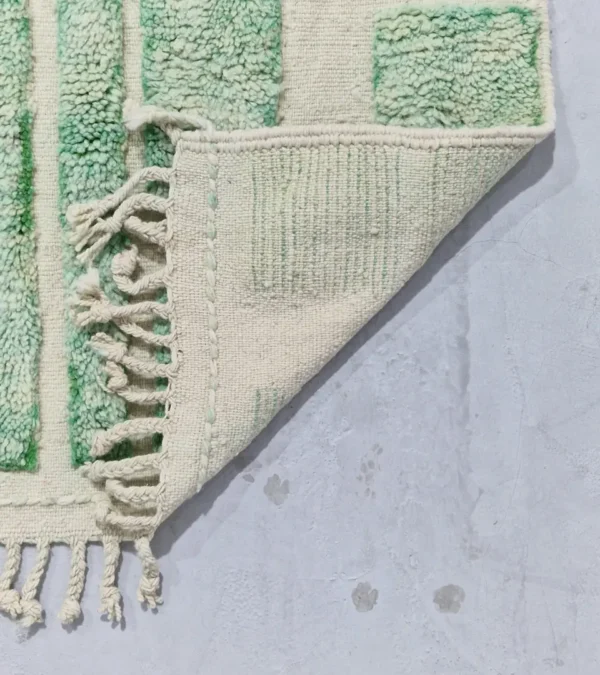 Detailed View of Ruby handmade Moroccan wool rug with a textured, raised abstract design in green and ivory