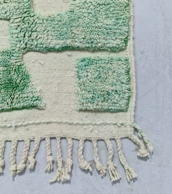 Detailed View of Ruby handmade Moroccan wool rug with a textured, raised abstract design in green and ivory