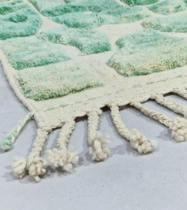 Detailed View of Ruby handmade Moroccan wool rug with a textured, raised abstract design in green and ivory