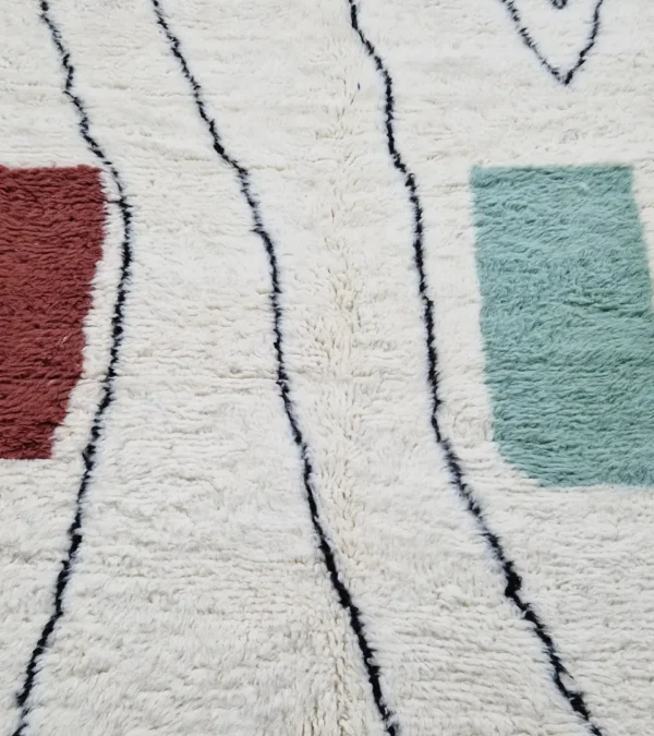 Detailed View of Salma handmade Azilal wool rug with a minimalist geometric design featuring a yellow triangle, teal rectangle, and burgundy rectangle on an ivory background