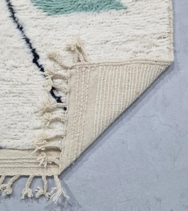 Detailed View of Salma handmade Azilal wool rug with a minimalist geometric design featuring a yellow triangle, teal rectangle, and burgundy rectangle on an ivory background