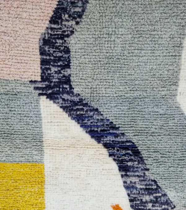 Detailed View of Sanaa handmade Beni Ourain wool rug with a contemporary abstract design in multicolor hues including lavender, grayish-green, mustard yellow, dark teal, and golden brown