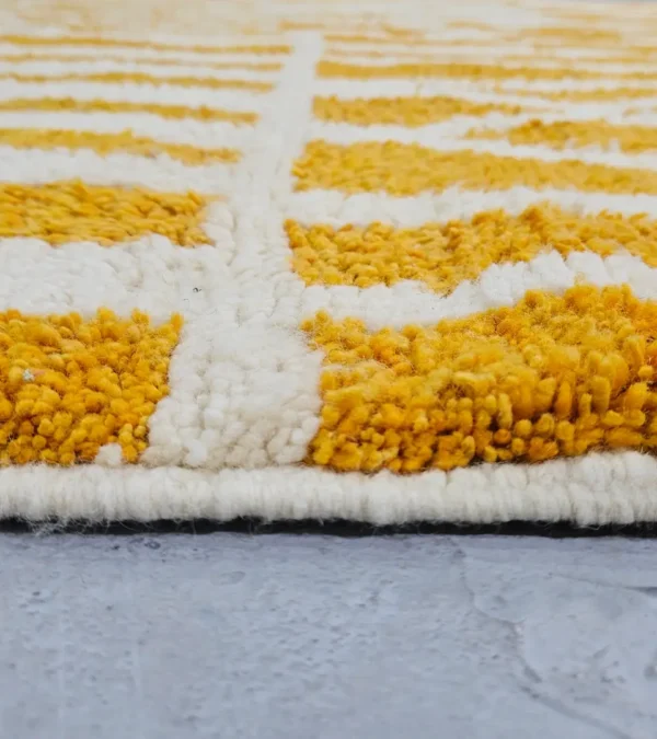 Zoomed In View of Sara handmade Beni Ourain wool rug with a modern striped and abstract design in yellow and ivory