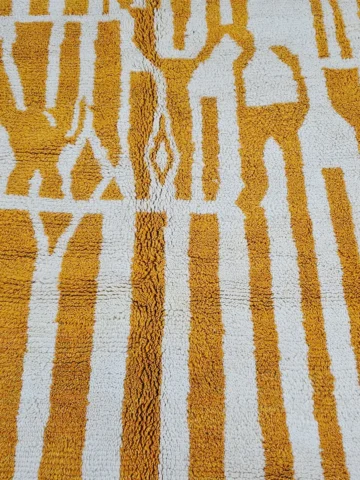 Detailed View of Sara handmade Beni Ourain wool rug with a modern striped and abstract design in yellow and ivory