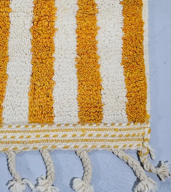 Detailed View of Sara handmade Beni Ourain wool rug with a modern striped and abstract design in yellow and ivory