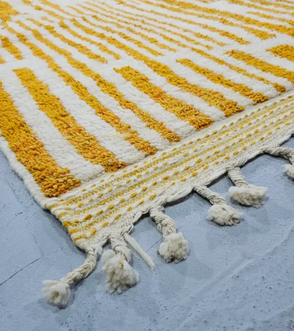 Detailed View of Sara handmade Beni Ourain wool rug with a modern striped and abstract design in yellow and ivory