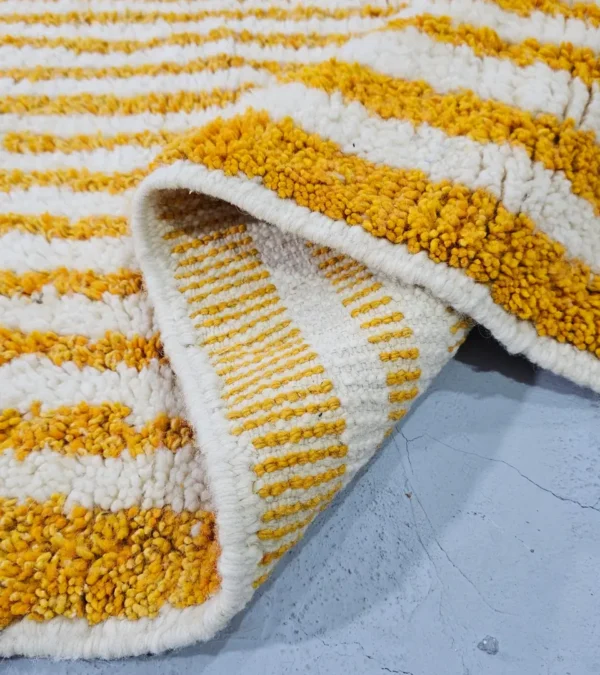 Detailed View of Sara handmade Beni Ourain wool rug with a modern striped and abstract design in yellow and ivory