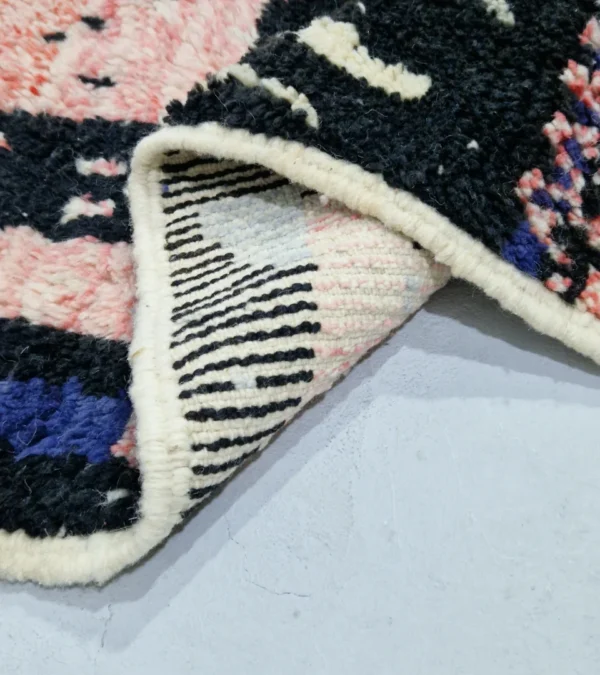 Detailed View of Handmade Moroccan wool rug with an abstract geometric design in pink, blue, and black