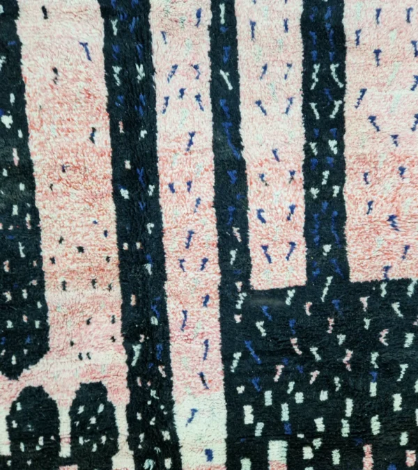 Detailed View of Handmade Moroccan wool rug with an abstract geometric design in pink, blue, and black