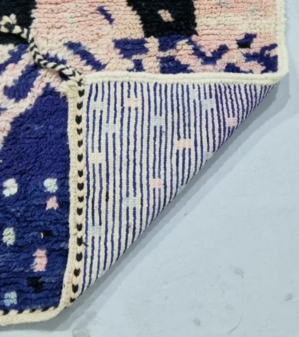 Detailed View of Handmade Moroccan wool rug with an abstract geometric design in pink, blue, and black