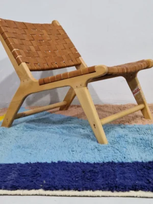 Handmade Moroccan wool rug with a geometric color-block design in blue, orange, and yellow in room