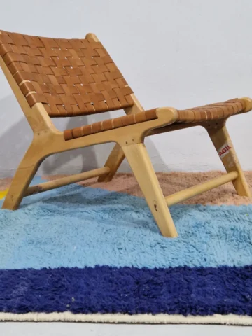 Handmade Moroccan wool rug with a geometric color-block design in blue, orange, and yellow in room