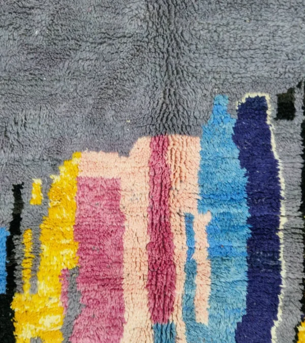 Detailed View of Handmade Moroccan wool rug with an abstract skyline design in multi-color on a gray background