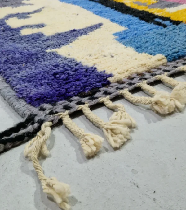 Detailed View of Handmade Moroccan wool rug with an abstract skyline design in multi-color on a gray background