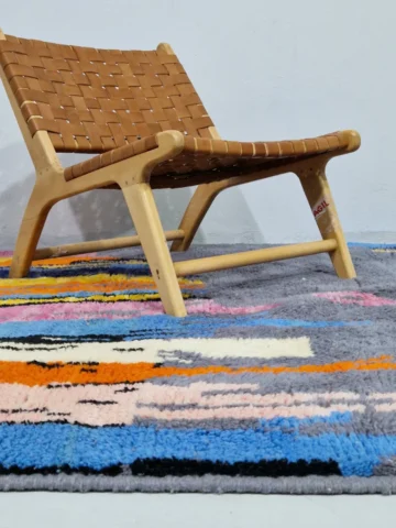 Handmade Moroccan wool rug with an abstract skyline design in multi-color on a gray background in room