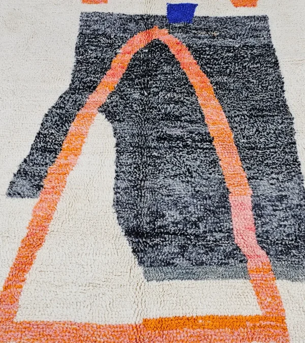 Detailed View of Soraya handmade Beni Ourain wool rug with a minimalist geometric design in dark gray, burnt orange, and bright blue on an ivory background