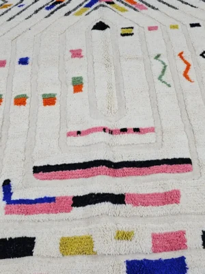 Detailed View of Suzan handmade Beni Ourain wool rug with a bold chevron and abstract raised maze design in black and multicolor on an ivory background