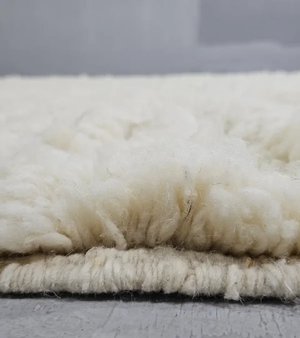 Zoomed In Viw of Handmade Moroccan Beni Ourain wool rug with a minimalist geometric pattern and extra soft shag pile in a natural ivory color