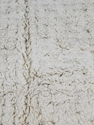 Detailed View of Handmade Moroccan Beni Ourain wool rug with a minimalist geometric pattern and extra soft shag pile in a natural ivory color