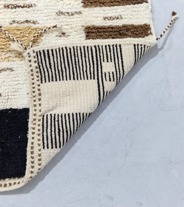 Detailed View of Talia handmade Beni Ourain wool rug with a textured plush design in cloud ivory, black, and brown
