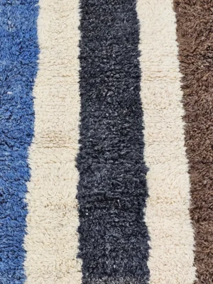 Detailed View Of Tareen handmade Beni Ourain wool runner with a colorful lines design in brown, teal-blue, dusty blue, mustard yellow, and ivory
