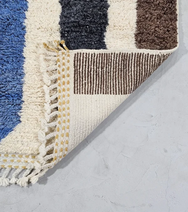 Detailed View Of Tareen handmade Beni Ourain wool runner with a colorful lines design in brown, teal-blue, dusty blue, mustard yellow, and ivory