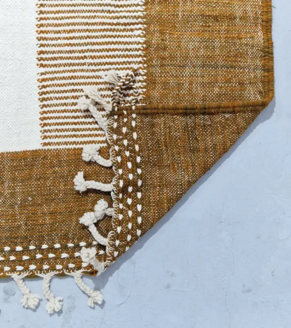 Detailed View of Taya handmade Kilim flatweave wool rug with a brown striped border and a large white central rectangle