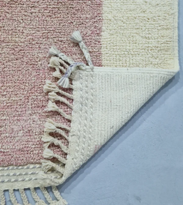 Detailed View of Handmade Moroccan plush wool rug with a modern cloud-like abstract design in muted pink, yellow, and gray