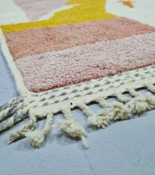 Detailed View of Handmade Moroccan plush wool rug with a modern cloud-like abstract design in muted pink, yellow, and gray