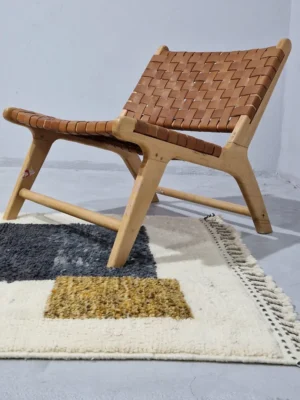 Yara handmade Beni Ourain wool rug with a modern geometric pattern and tassel fringe in charcoal gray, mustard yellow-brown, and ivory in room