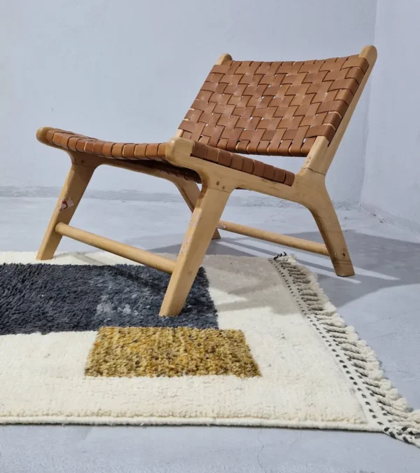 Yara handmade Beni Ourain wool rug with a modern geometric pattern and tassel fringe in charcoal gray, mustard yellow-brown, and ivory in room
