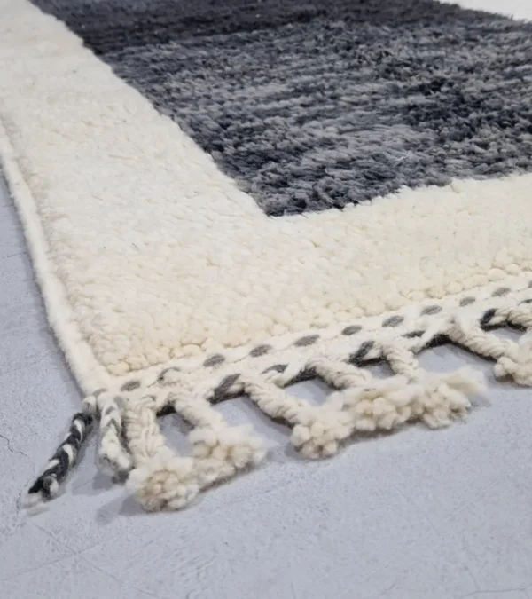 Detailed View of Yara handmade Beni Ourain wool rug with a modern geometric pattern and tassel fringe in charcoal gray, mustard yellow-brown, and ivory