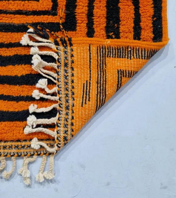 Detailed View of Handmade Moroccan wool rug with orange and navy concentric square stripes