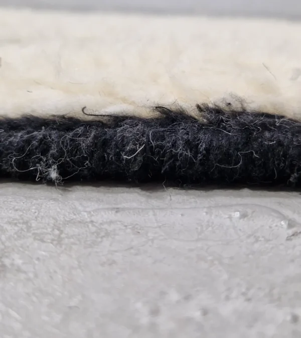 Zoomed In View of Zebra handmade Beni Ourain wool rug with a bold black and white striped pattern and varying pile height