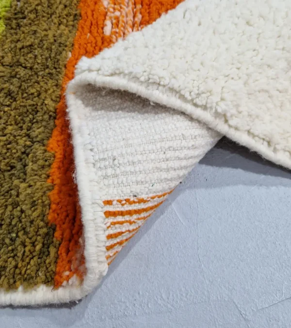 Detailed View of Zera handmade Beni Ourain wool rug with a contemporary abstract design in multicolor hues of green, orange, and brown