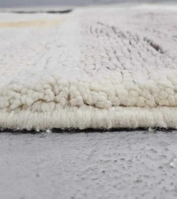 Zoomed In View of Zira handmade Moroccan wool rug with a minimalist geometric blocks design in black, lavender, and beige