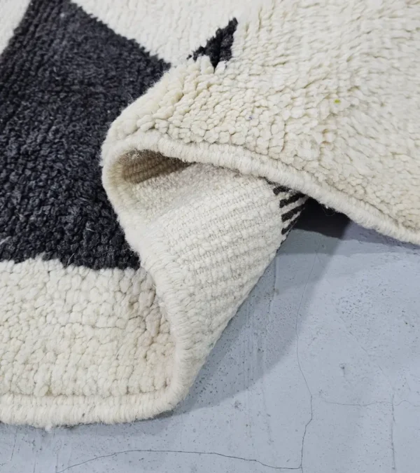 Detailed View of Zira handmade Moroccan wool rug with a minimalist geometric blocks design in black, lavender, and beige