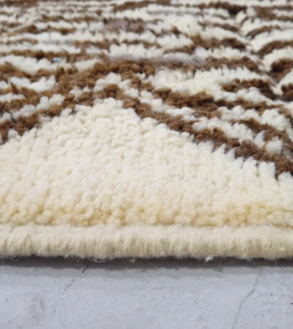 Zoomed In View of Zira handmade Beni Ourain wool rug with a textured geometric design in brown, gray, and ivory